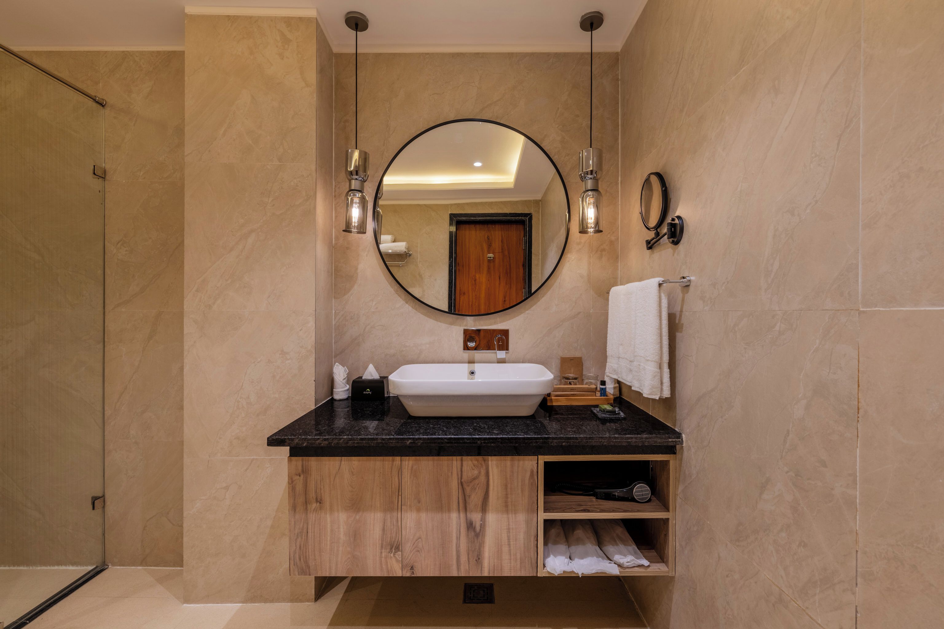 Un baño moderno con una bañera independiente, un espejo grande y un tocador de madera.