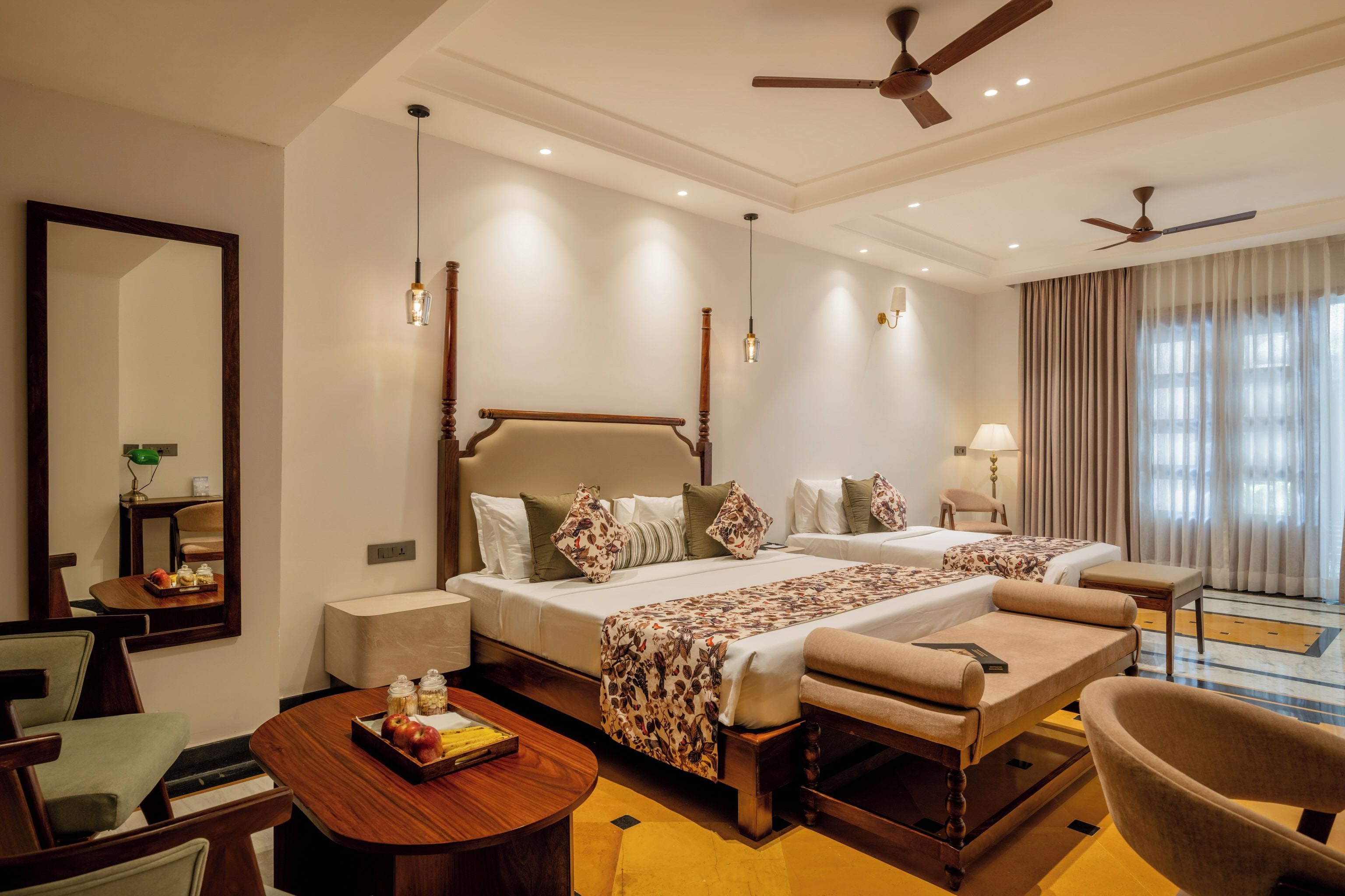 A hotel room with a double bed, a desk, a chair, and a dining table.