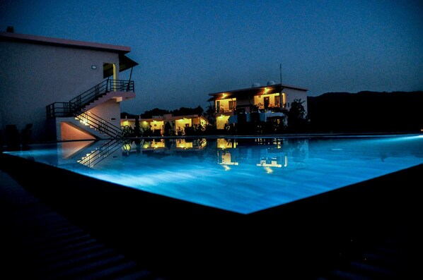 Relax by the pool, surrounded by a contemporary design with a prominent staircase leading to a spacious balcony.