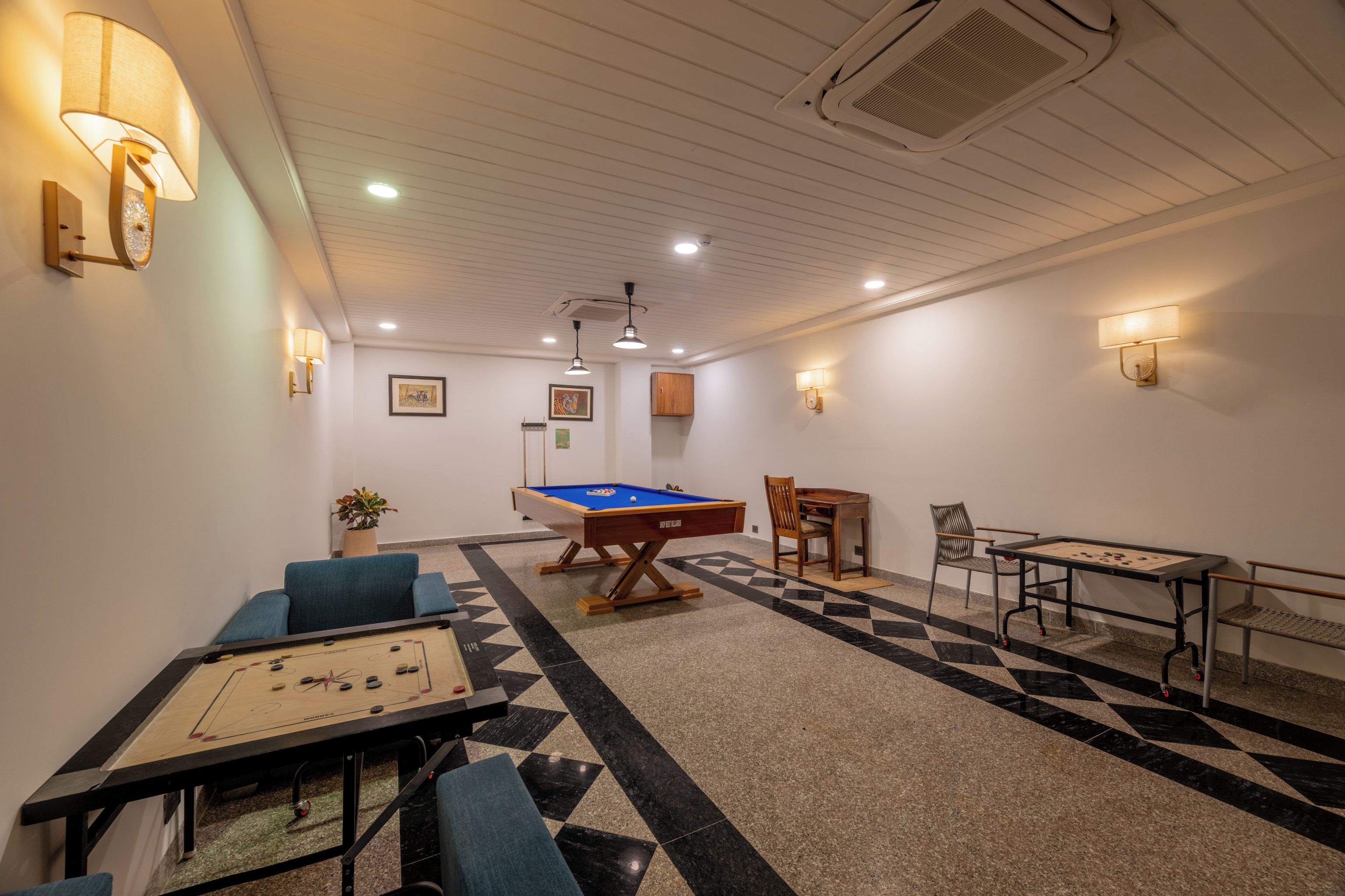 Ein Zimmer mit Billardtisch, Kicker und Snookertisch.