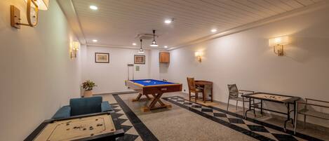 Ein Zimmer mit Billardtisch, Kicker und Snookertisch.