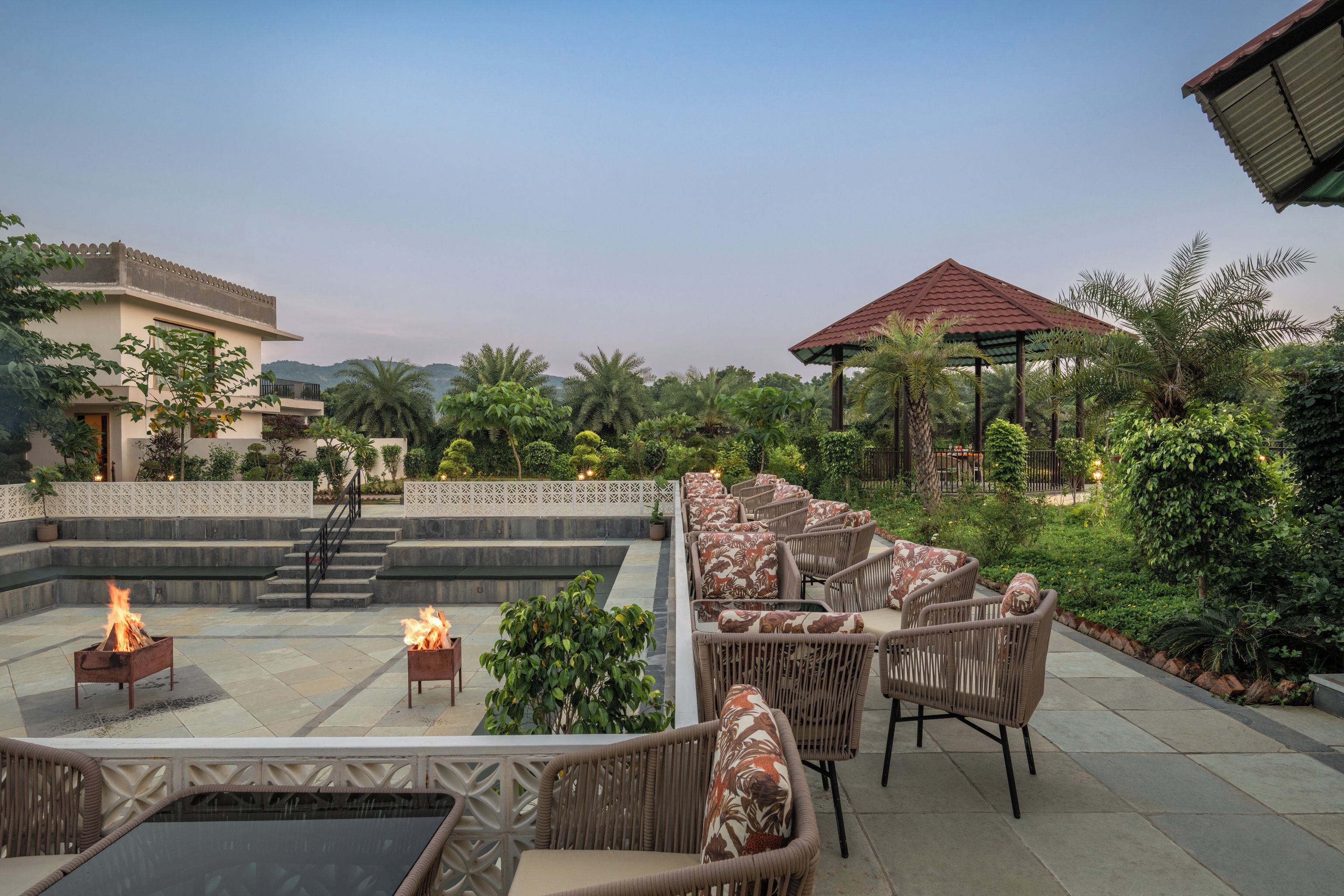 A rooftop terrace with outdoor seating, a fire feature, and a view of the surrounding landscape.