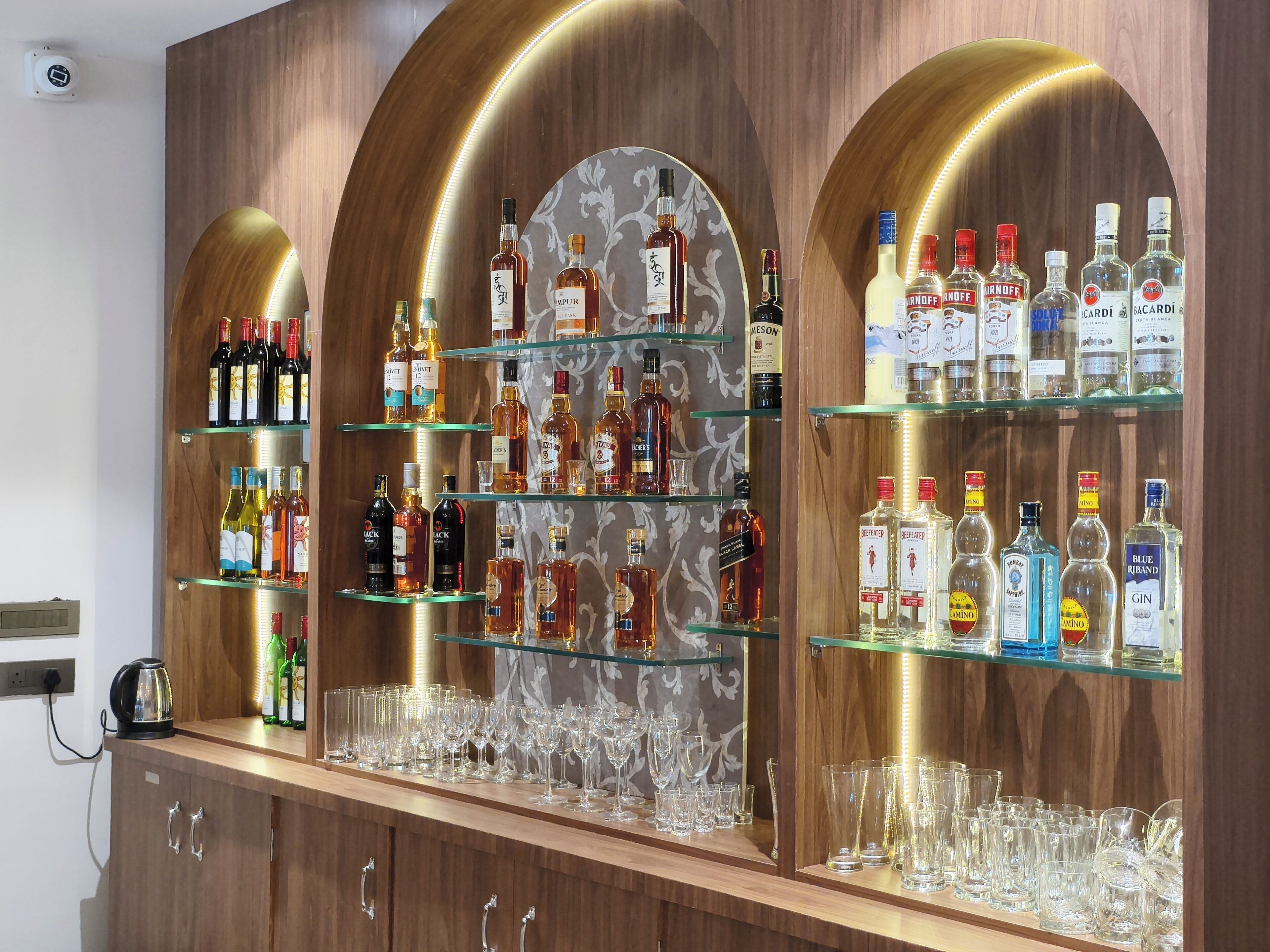 A bar area with shelves of liquor bottles and glasses.