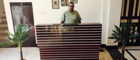 A reception desk labeled "RECEPTION" with clocks displaying times from India, Tokyo, London, and New York.