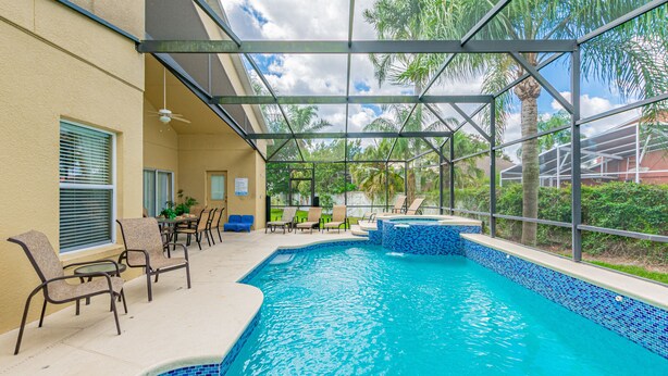 An indoor swimming pool with clear blue water, surrounded by lounge chairs and a covered patio area. - 7 Beds, 7 Bath Acadia Estates Home with Private Pool and Spa Minutes to Disney! (Kissimmee)