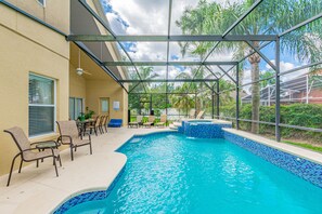 An indoor swimming pool with clear blue water, surrounded by lounge chairs and a covered patio area. - 7 Beds, 7 Bath Acadia Estates Home with Private Pool and Spa Minutes to Disney! (Kissimmee)