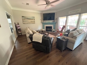 A living room with a fireplace, a sofa, a chair, and a television.
