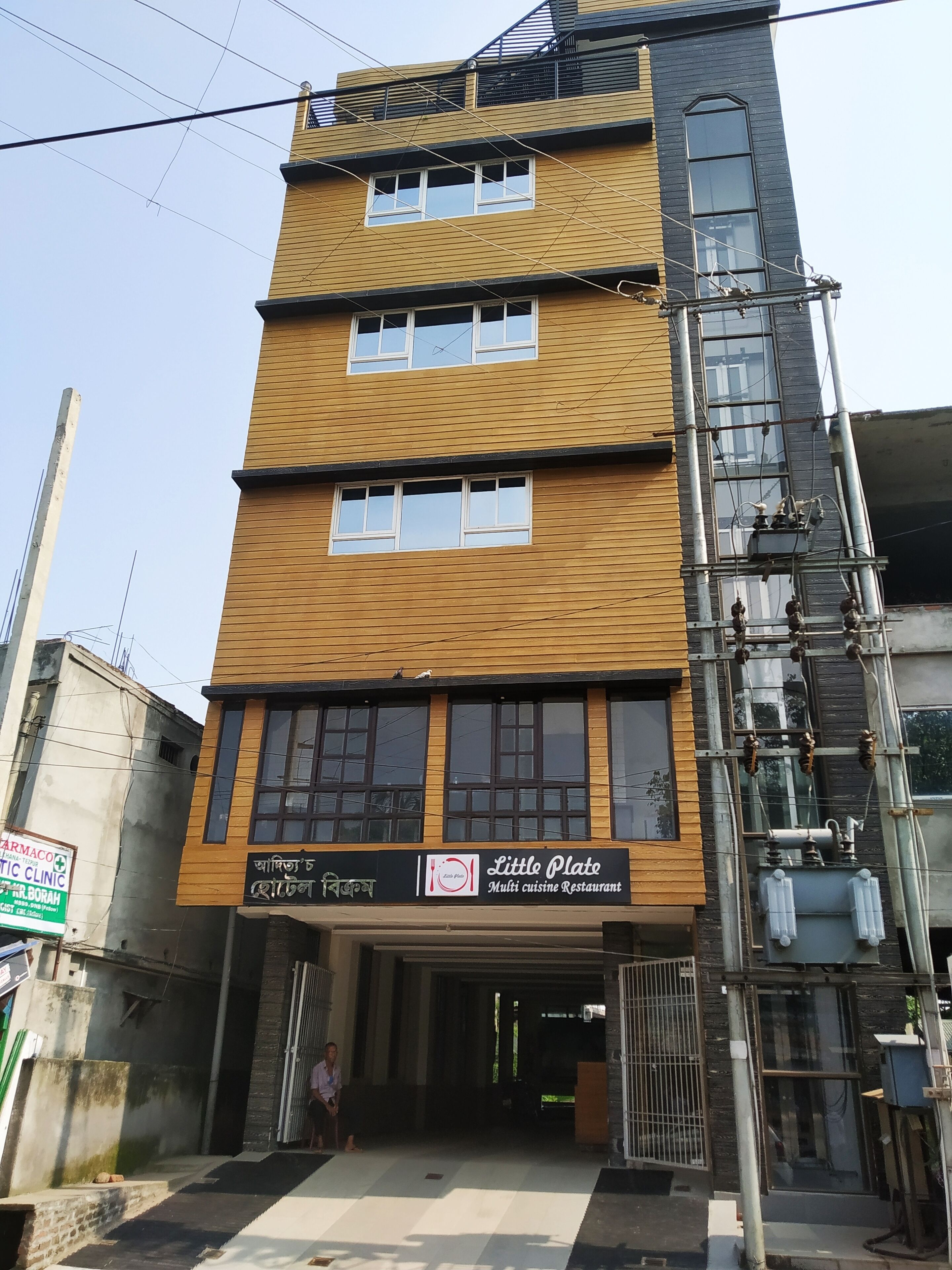 Un edificio de varios pisos con un restaurante llamado "Little Plate" en la planta baja.