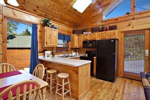 Enjoy cooking in this well-equipped kitchen with a central island, stove, microwave, and refrigerator.