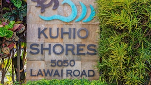 Segnaletica per "KUHIO SHORES" in via LAWAII 5050, circondata da vegetazione lussureggiante.