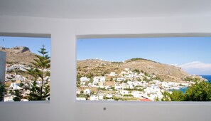 Vue depuis une terrasse située à un étage inférieur, donnant sur des moulins à vent et un château.