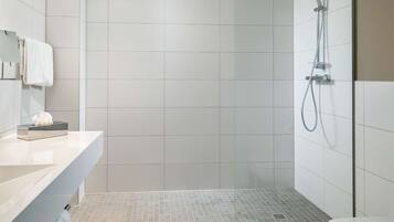 Un baño moderno con ducha, inodoro y tocador.