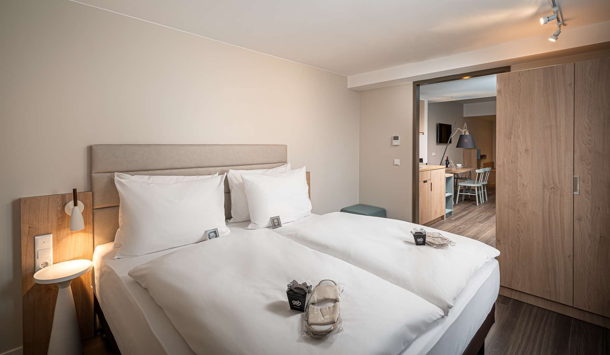 Une chambre d’hôtel avec un grand lit, des tables de chevet, un bureau et une armoire.