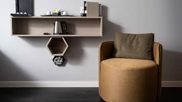 Un interior moderno con un sillón redondo y de textura, y una estantería minimalista.