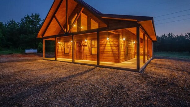 Een moderne blokhut met een grote glazen voorgevel en een schuin dak.