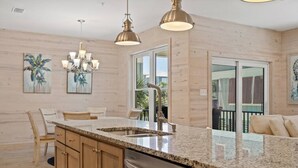 A modern kitchen with granite countertops, stainless steel appliances, and wooden cabinets. - Hammock Dunes I - Private Cottage Beach Side (Orange Beach)