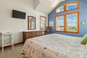A bedroom with a bed, dresser, and a TV mounted on the wall. - Gramp's Dream: 440 Ft to Beach, Pool, Hot Tub & Dog-friendly (Southern Shores)