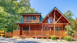 A log cabin with a front porch, a second story, and a steeply pitched roof. - Black Bear Ridge - 5 Bedroom minutes from the Parkway! (Sevierville)