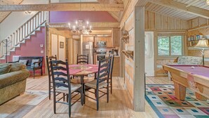 A spacious living area with a wooden ceiling, a dining table with chairs, a pool table, and a staircase leading to an upper level. - Bear Den-Mountain Log Cabin, Wood Fireplace, Pool Table, Gas Grill (Seven Devils)