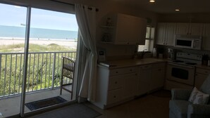 A kitchen with a view of the beach, a ceiling fan, and a sign that says "beach". - Amazing one bedroom direct ocean front condo with beautiful view of the ocean! (COCOA BEACH)