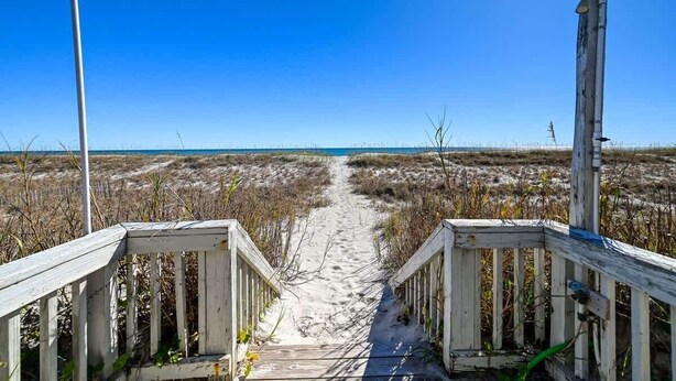 A wooden boardwalk leading to a beach with sand and sparse vegetation. - SeaClusion South - Oceanfront - Dog Friendly (Topsail Beach)