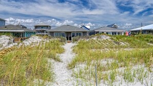 A beachfront property with multiple houses and a sandy path leading to the entrance. - SeaClusion South - Oceanfront - Dog Friendly (Topsail Beach)