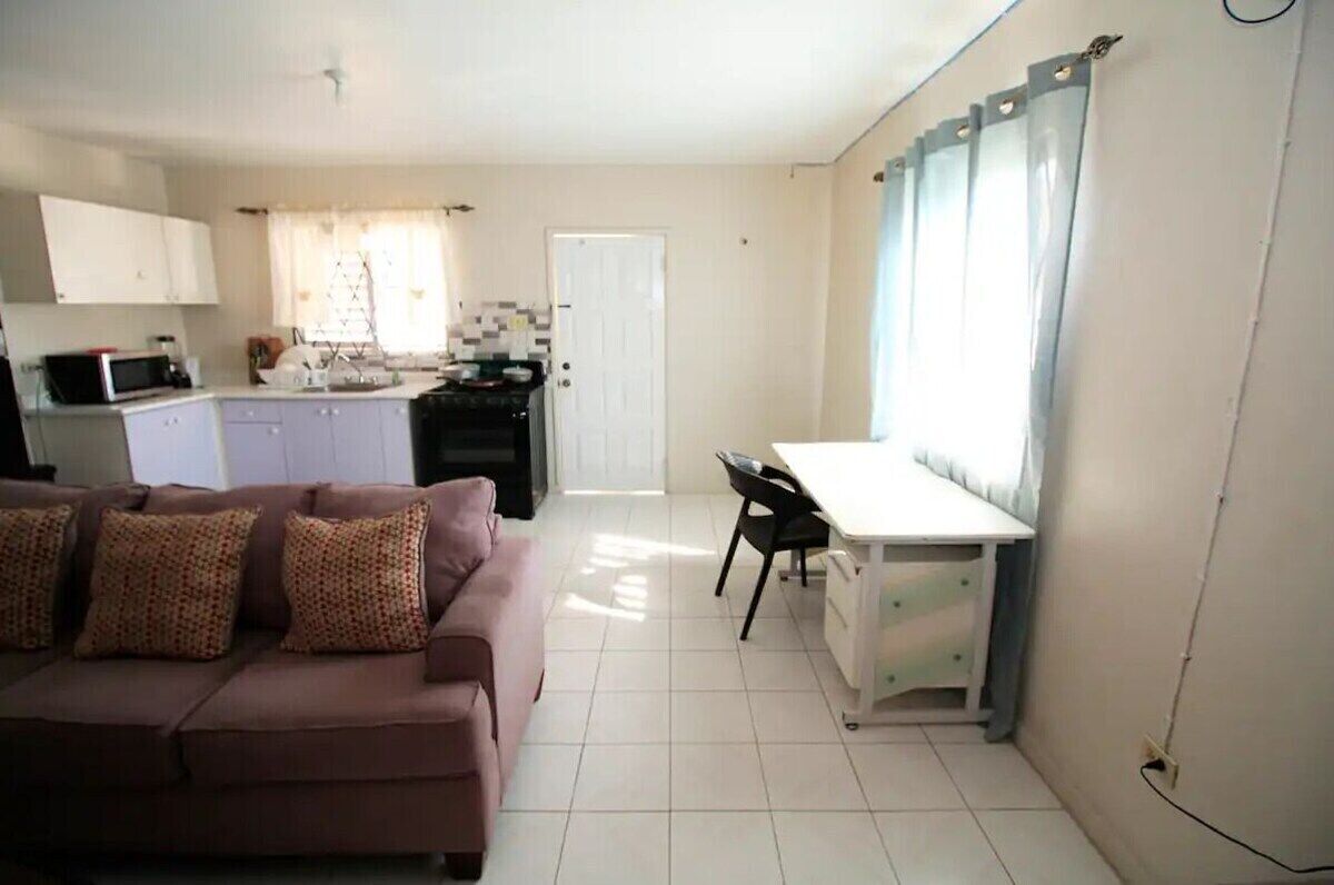 Un espacio habitable compacto con kitchenette, comedor y sofá.