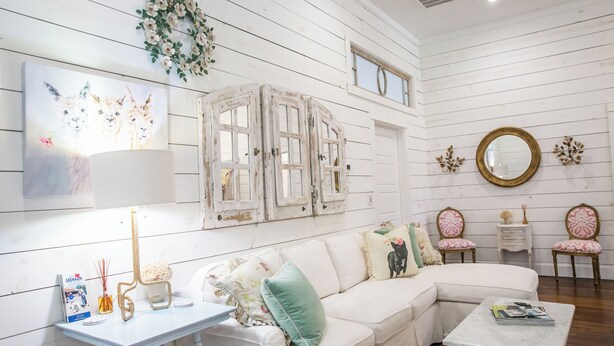 A white wooden interior with a white sofa, a small table, two chairs, and a mirror on the wall. - Pigs Fly in Burton just minutes to Round Top Antiques Shopping and Dining (Burton)