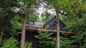Eine Hütte mit einem Balkon, umgeben von dichtem Wald.
