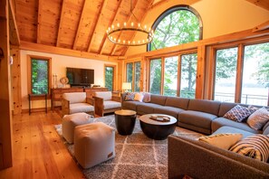 A spacious living room with a large sectional sofa, a television, and a fireplace.