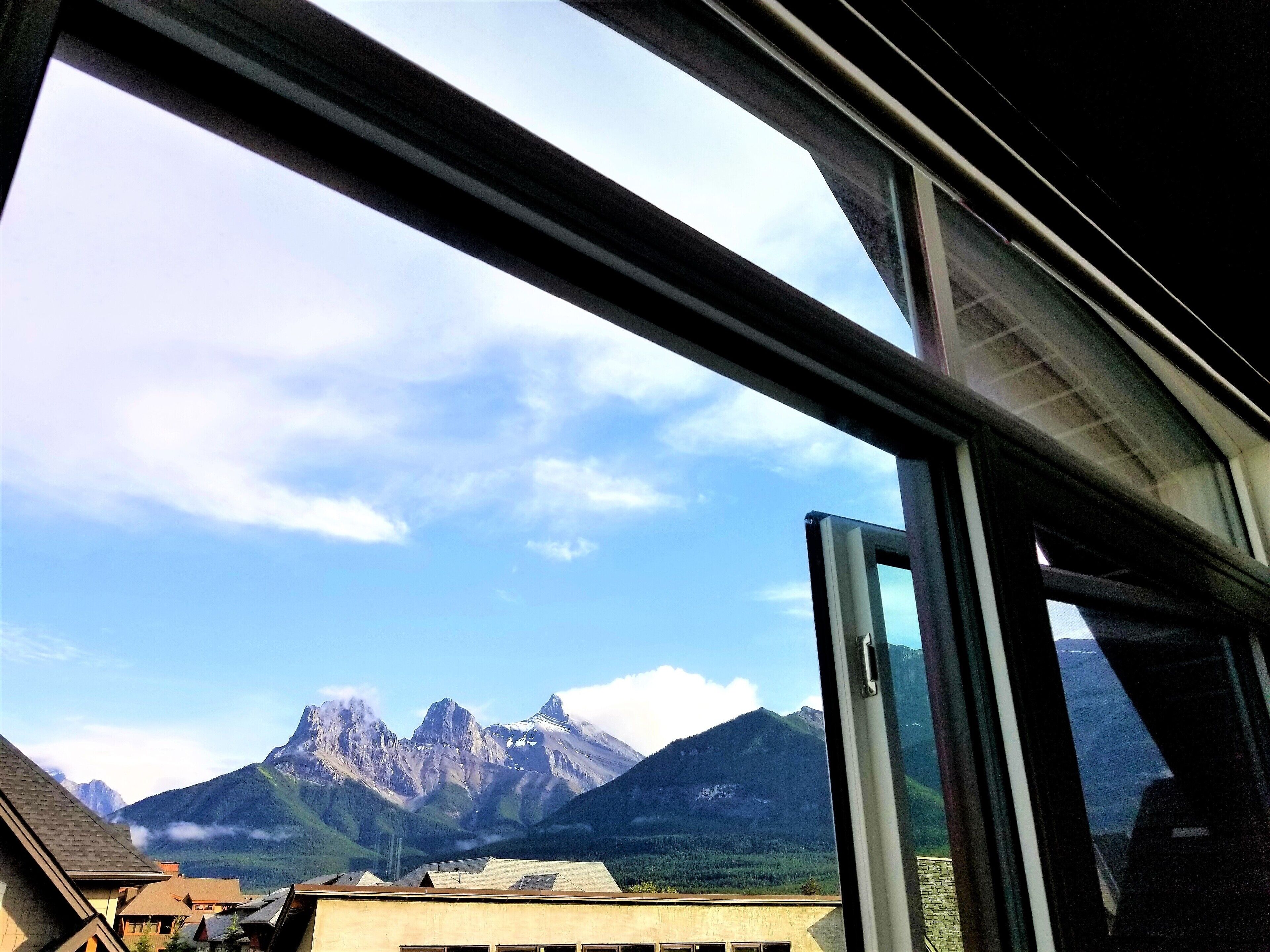 A mountain view through a window with a clear sky.