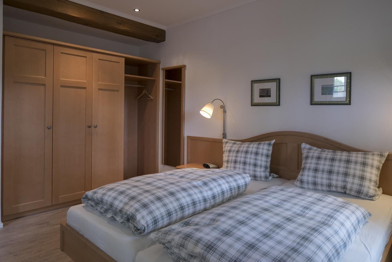 A bedroom with a double bed, a wardrobe, and a bedside table with a lamp.