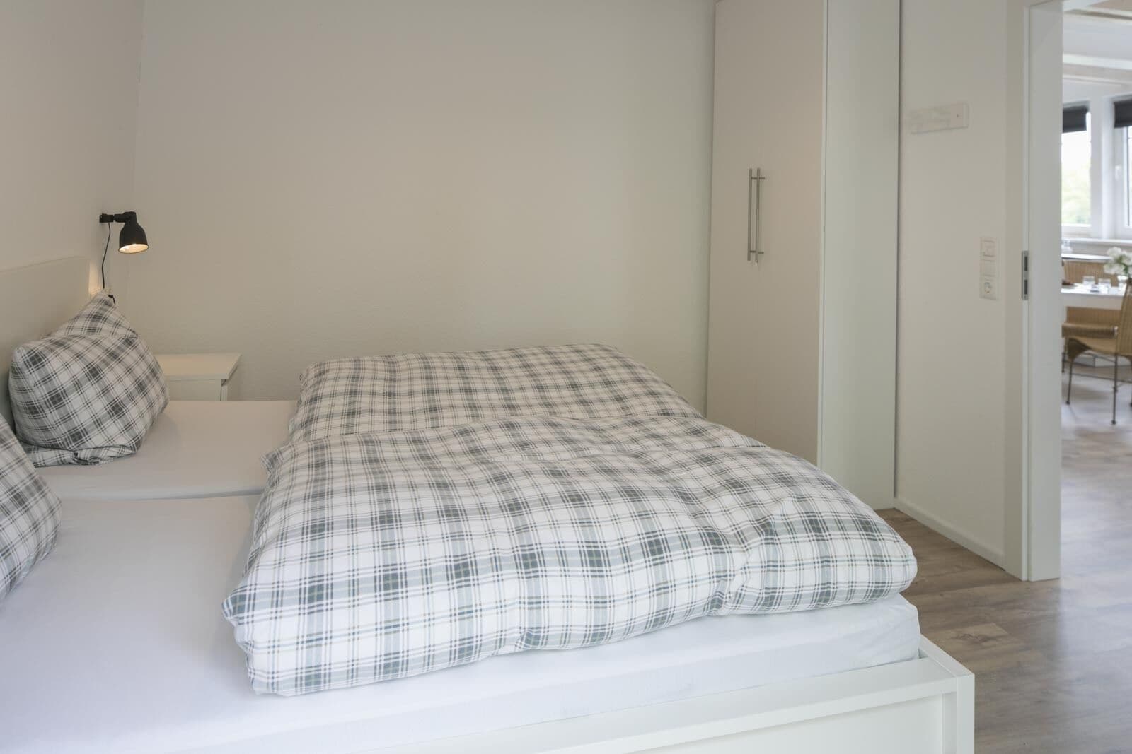 Une chambre à coucher avec un lit, une table de chevet, une lampe et une armoire.