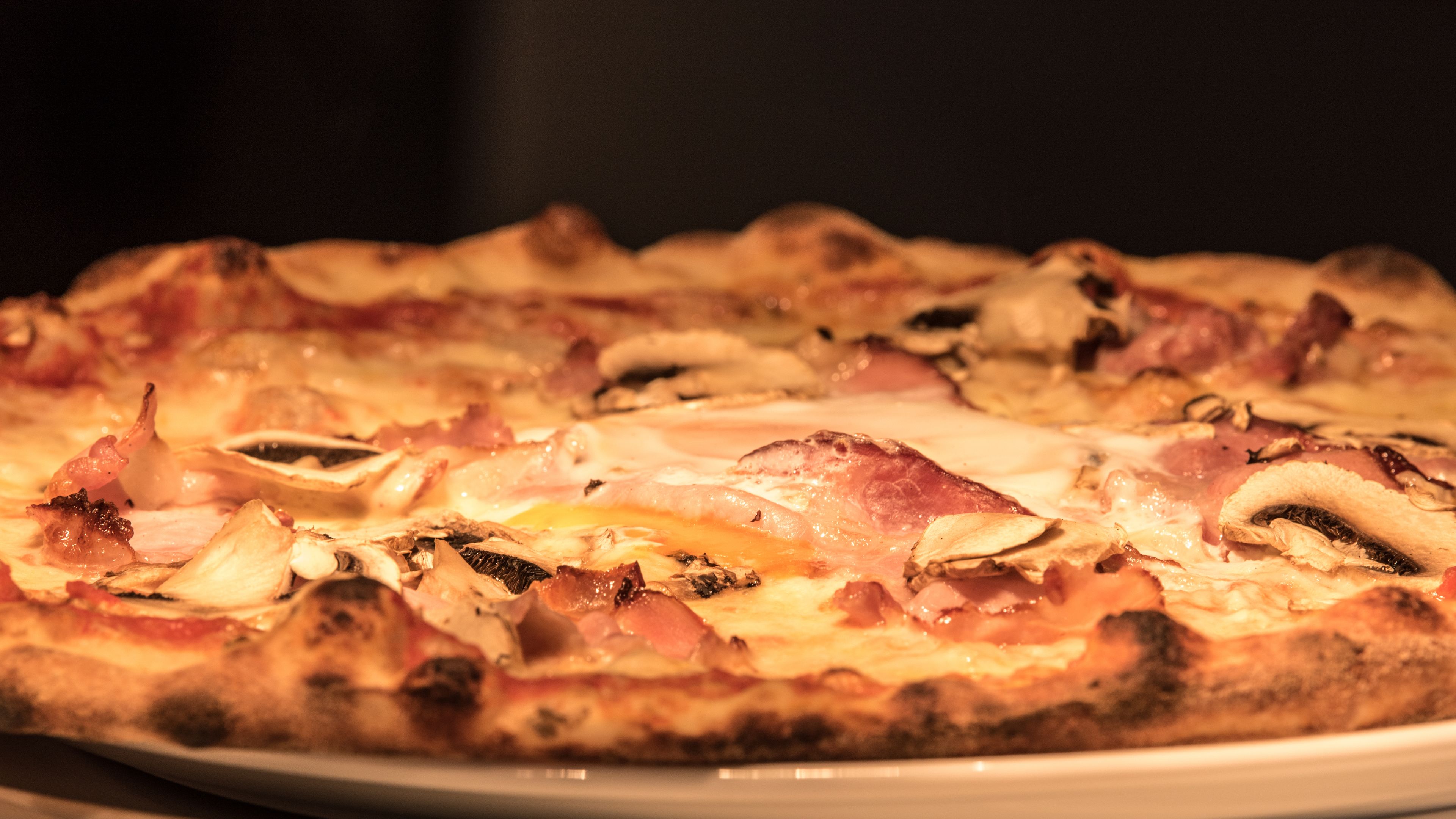 Una pizza con diferentes ingredientes sobre un plato blanco.