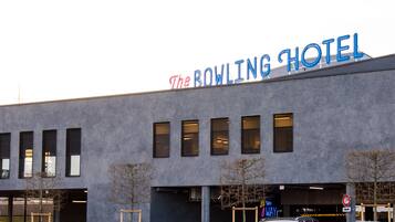 The Bowling Hotel with a modern facade, multiple windows, and a neon sign.