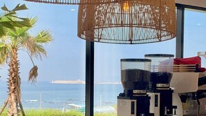 A coffee machine with a view of the ocean and palm trees. - Hotel Seogwipean (Seogwipo)