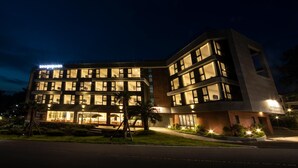 A multi-story hotel with illuminated windows and a sign that reads "seopoeon". - Hotel Seogwipean (Seogwipo)
