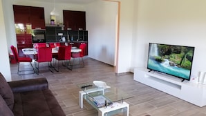 A modern living room with a sofa, a coffee table, and a TV on a stand. - Ivan's holiday home (Zemunik Donji)