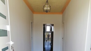 A hallway with wooden flooring, white walls, and a ceiling light fixture. - Ivan's holiday home (Zemunik Donji)