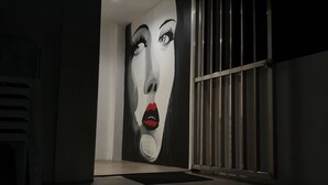 A hallway with a large mural of a woman's face on the wall. - Hotel Zenturia (Boac)