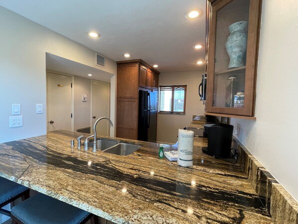 A kitchen with granite countertops, stainless steel appliances, and wooden cabinets. - Updated 2 Bedroom, 2 Bath Gulf View with 2 Lanais! (Siesta Key)