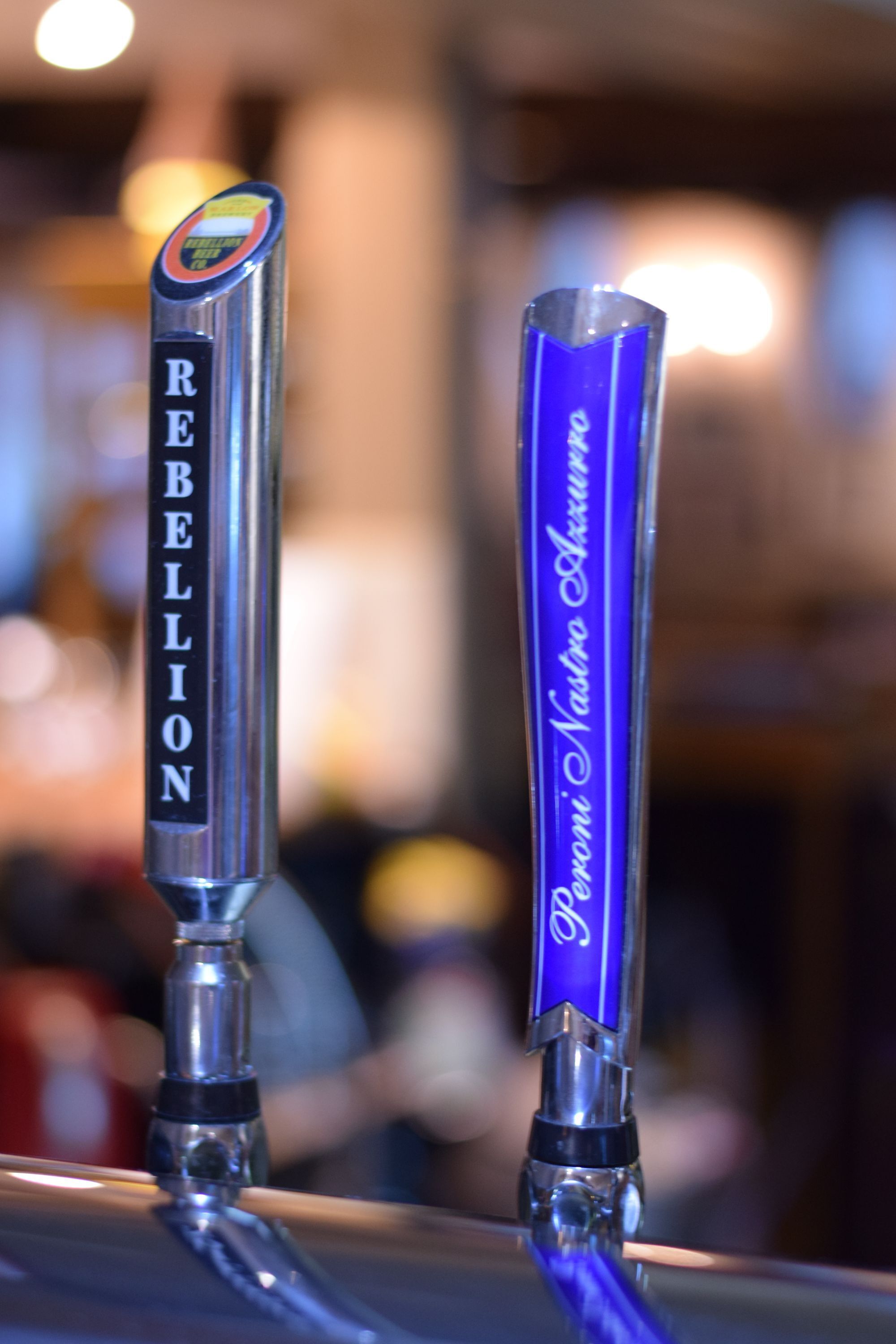Two beer taps labeled "Rebellion" and "Pomeranian Nadel."