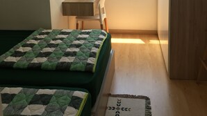 A bedroom with two beds, a desk, a chair, a window with a view, and a mirror. - Friendly host looking for polite guests (Tp. Vũng Tàu)