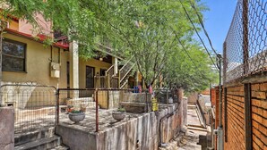 A narrow alleyway with a concrete staircase leading to a building with a metal fence and a sign. - Home w/ Gas Grill - Walk to Bisbee Brewing Co (Bisbee)