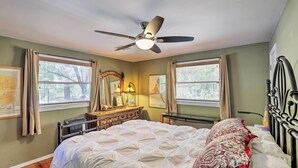 A bedroom with a bed, a ceiling fan, a dresser, and two windows with curtains. - Home w/ Gas Grill - Walk to Bisbee Brewing Co (Bisbee)