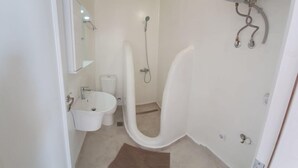 Un baño pequeño con inodoro, lavamanos y ducha.