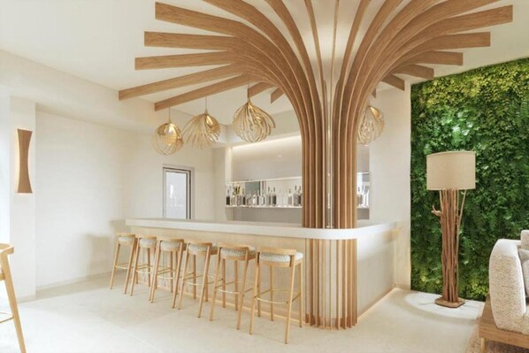 A modern kitchen with a central island, bar stools, pendant lights, and a green wall. - HL Hotel Rondo (San Bartolomé de Tirajana)