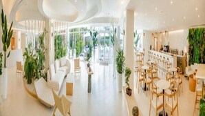 A modern hotel lobby with a seating area, a bar, and a view of the outdoors. - HL Hotel Rondo (San Bartolomé de Tirajana)