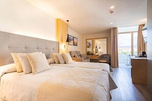 A hotel room with a large bed, a desk, and a view of the outdoors. - HL Hotel Rondo (San Bartolomé de Tirajana)
