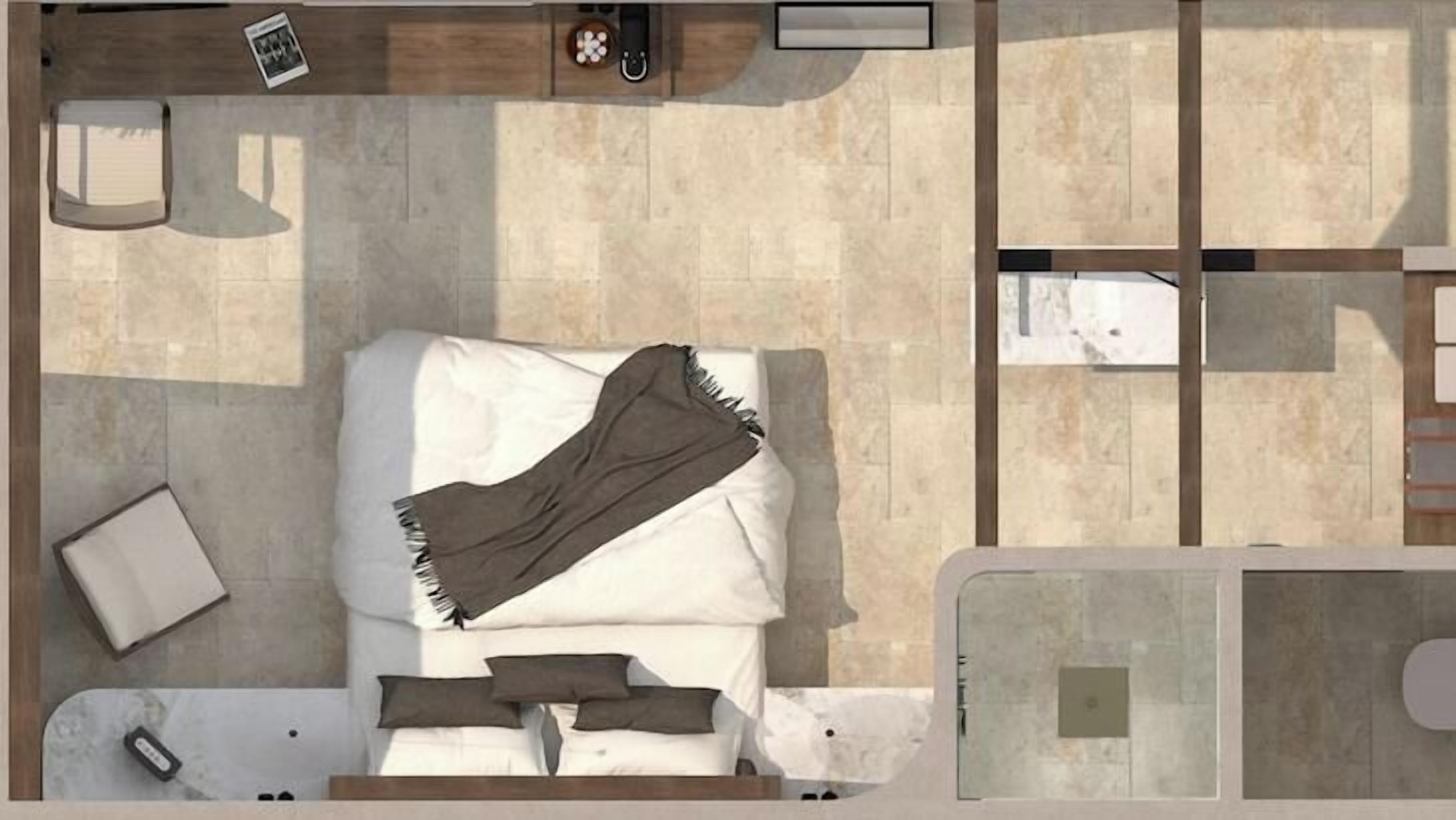An overhead view of a hotel room with a bed, a bedside table, a chair, and a small bathroom area.